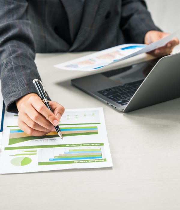businesswoman works diligently at her desk, reviewing financial documents and analyzing investment