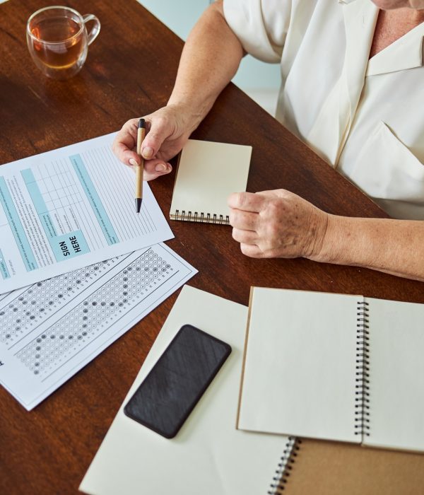 Elderly woman filling out taxes form at home