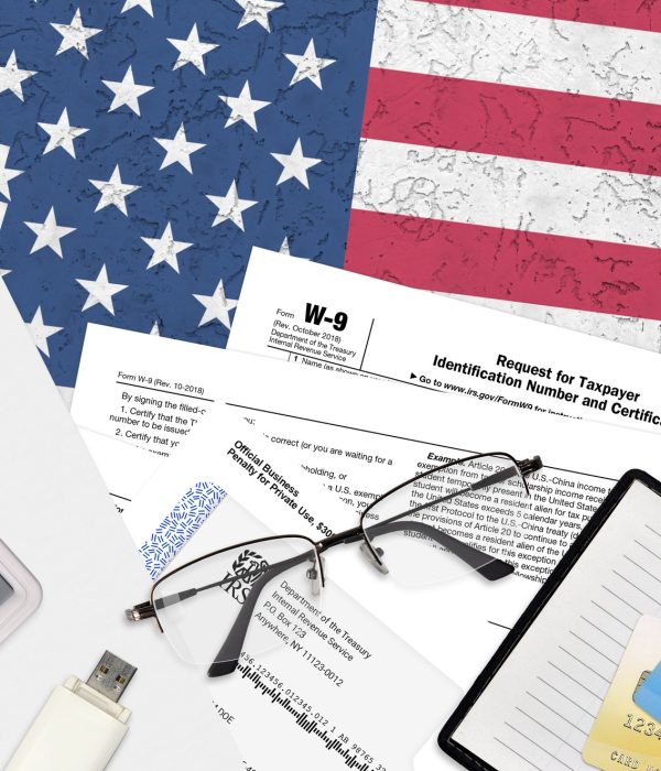 IRS form W-9 Request for taxpayer identification number and certification lies on flat lay office