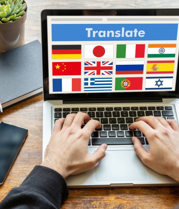 Man working on a laptop with the word translate on the computer screen